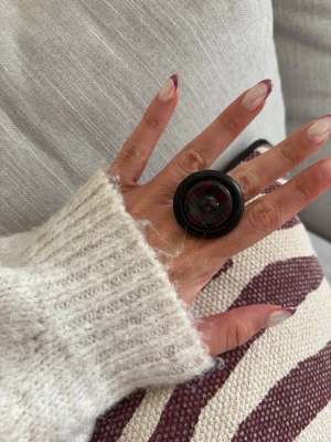 Ring med knapp  - Säljer denna handgjorda ring.  Knapparna är vintage men själva ringen/ringstommen är helt ny och oanvänd. Materialet är rostfritt stål och varken tappar färg eller färgar av sig på huden. Ringen tål vatten. Storleken är justerbar, man kan trycka ihop och dra isär ringen till önskad storlek. Perfekt för dig som vill bära något unikt!