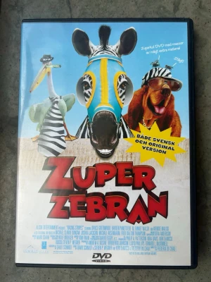 Zuper zebran dvd - DVD-film med titeln Zuper Zebra, även känd som Racing Stripes. Filmen är en familjefilm med både svensk och originalversion. Speltiden är 97 minuter och den är producerad år 2005. Filmen har barntillåten åldersgräns.  Finns på språk: Svenska, Engelska, Norska, Danska, Finska   OBS!! skivorna är begagnade så det kan förekomma repor/hairlines på skivorna, men då jag kollar igenom alla filmer jag säljer garanterar jag att alla funkar felfritt om inget annat står! :)