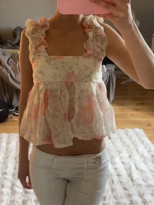 Topp/blus - Populära toppen/blusen ifrån H&M som har ett jättefint blommigt mönster! Man knyter den bak i ryggen💞fint skick men lite skrynklig bara!