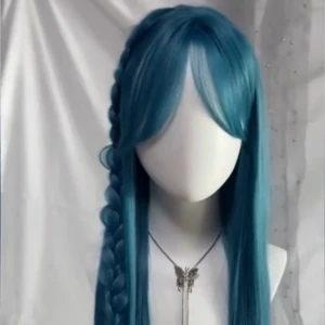 Lång blå peruk med lugg - Snygg lång peruk i intensivt blå färg med rak lugg.Peruken har naturlig glans och raka längder, perfekt för att sticka ut eller cosplay. Tillverkad i syntetmaterial som är lätt att styla. Den kommer inte stylad.