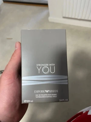 Emporio Armani Stronger With You 100ml - Emporio Armani Stronger With You är en herrparfym i en stilren, fyrkantig glasflaska med silverfärgad rund kork. Doften är varm och modern, perfekt för dig som gillar eleganta och maskulina toner. Förpackningen är grå med silverdetaljer och rymmer 100 ml eau de toilette.