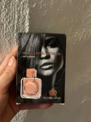 Svart parfymförpackning 100 ml - Snygg parfym i svart kartong med en bild på en ljusrosa flaska på framsidan. Förpackningen rymmer 100 ml och har en modern, stilren design. Perfekt för dig som gillar exklusiva dofter och vill ha en elegant parfymflaska i samlingen. Använd par gånger.