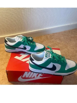 Helt nya aldrig använda Nike Dunk Low grön/vit sneaker - Priset går att diskutera! Mycket snygga. Helt nya, aldrig använda. + Få extra tillbehöret, nya vita nike skosnören med gratis! Först till kvarn gäller! Storlek 40 men känns mer som 39, töjer nog ut sig efter användning. Först till kvarn gäller!