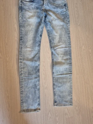 Ljusblå skinny jeans med tvättad look - Säljer ett par ljusblå skinny jeans med snyggt tvättad effekt och klassisk femficksmodell. Jeansen har smal passform och normal midja. Från H&M storlek w29L30. Katt finns I hemmet