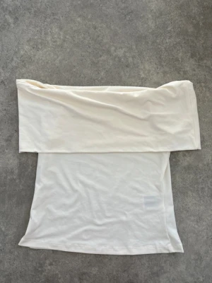 Vit axelbandslös tubtopp - Jättesnygg off shoulder topp från hm i stolek S❣️ Den är i nytt skick! Skriv om ni vill ha fler bilder.