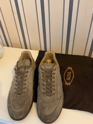 TOD'S Mocka Sneakers - TOD'S Stiliga Beige Mocka Sneakers i storlek UK 8 (42 motsvarande) Mens Size. Använt i en vecka i Valdisere och skulle troligtvis behöva en rengöring. Saknar sulorna. 