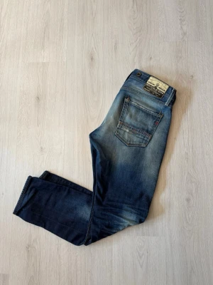 Replay Jeans - Snygga blå jeans från Replay i slim fit-modell med klassisk femficksdesign. Jeansen har slitningar och ljusare partier framtill och baktill för en cool, använd look. Tillverkade i bomull med en bekväm passform och detaljerade sömmar.