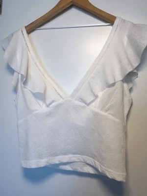 Vit volangtopp - Jättefin vit volang topp från bershka, ryggen ser likadan ut med urringning 🌸