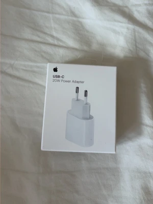Apple USB-C 20W strömadapter - Säljer en vit Apple USB-C 20W strömadapter. Perfekt för att ladda din iPhone eller iPad snabbt och smidigt. Kompakt och stilren design i plast med EU-kontakt. Passar alla enheter med USB-C laddningskabel.