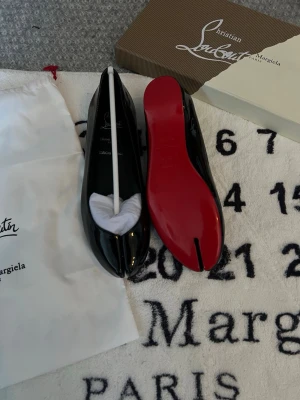Marlougiela - Marlougiela (Maison Margiela x Louboutin 🩸) flats i storlek 37. Ett exklusivt samarbete mellan två ikoniska varumärken❤️  Skorna är använda cirka två gånger och är i mycket fint skick utan några defekter🙌 Säljs utan originalkartong 📦  Jag är mycket aktiv här så svarar snabbt på meddelanden. Skickar inom 48 timmar på vardagar 📦🌱  