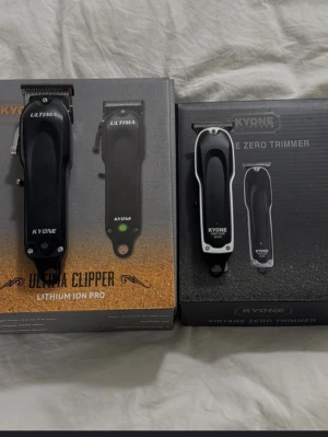 Kyone hårtrimmer och klippmaskin - Säljer ett set med Kyone Ultima Clipper Lithium Ion Pro och Kyone Vintage Zero Trimmer. Båda är svarta med silverdetaljer och har ergonomisk form. Perfekt för att trimma och klippa hår med precision. Laddningsbara och smidiga att använda.