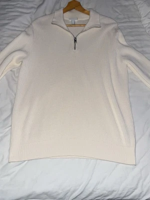 Vit stickad halvzip från H&M - Vit stickad tröja från H&M i slim fit-modell med halv dragkedja och krage. Perfekt för lager-på-lager och enkel att matcha med jeans eller kjol. Mjuk och skön känsla, långärmad och stilren design.