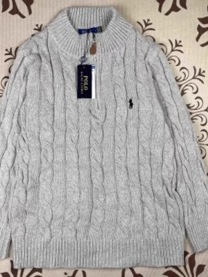 Grå kabelstickad tröja Polo Ralph Lauren - Snygg grå kabelstickad tröja från Polo Ralph Lauren med halv dragkedja och hög krage. Tröjan har det klassiska broderade logotypen på bröstet och ribbade muddar. Perfekt för lager-på-lager och en stilren look.