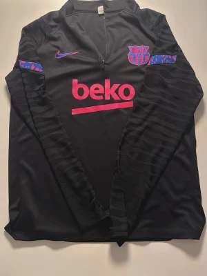 En fin fotbolls tracksuit  - En Barca tracksuit med ett tema av rosa svart och blå, bra skick
