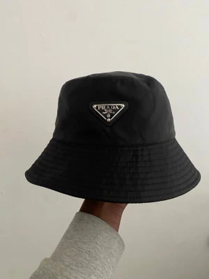 Svart Prada Bucket hat - Stilren svart bucket hat från Prada i perfekt skick passar fint nu till sommaren.