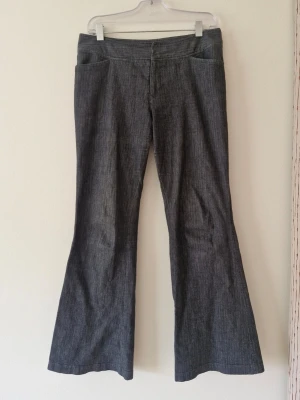 Mörkgrå bootcut kostymbyxor - Supersnygga utsvängda kostymbyxor! Vintage köpta på Beyond Retro 💕 Midjemått 42x2 cm, grenhöjd 22, innerbenslängd 73.