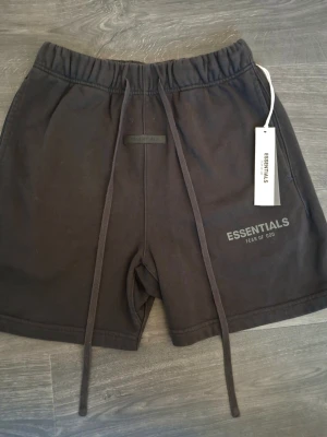 Essential Fear Of God Shorts - Fear of God Essentials Reflective Shorts – Strl S Säljer ett par Fear of God Essentials reflective shorts i storlek S. Kommer med påse och tags. Reflekterande print/logga som syns i mörker med blixt/ljus. Väldigt bra skick, köptes nya och har inte använts mycket. Inner-taggen är sliten så texten där har försvunnit. Osäker på autenticitet då jag köpt dem second hand. Priset är inte hugget i sten.