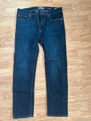  Dressmann jeans helt nya - Snygga mörkblå jeans från Dressmann i regular fit-modell. Klassisk femficksdesign med kontrastsömmar och dragkedjegylf. Perfekta för dig som gillar en tidlös och stilren look. Tillverkade i slitstarkt denimtyg.