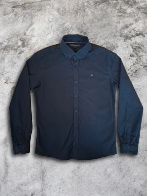 Tommy Hilfiger skjorta - Svart Tommy Hilfiger skjorta. Modellen är 173 cm, skjortan är storlek 164, den sitter ungefär som en Small. En skjorta i mycket bra skick som blir riktigt snyggt till både fest och vardagen🤙 Skriv gärna om ni har fler frågor!