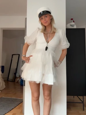 Vit kort volangklänning med puffärm perfekt för studenten  - Superfin vit kort klänning med volanger och puffärmar, perfekt till studenten om du frågar mig☺️Klänningen har flera lager i kjolen och bra längd som gör att man inte visar något. Använd en gång (på mitt utspring) sen bytte jag om till en annan💕