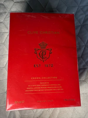 Clive Christian Crown Collection Matsukita - Lyxig parfym från Clive Christian i Crown Collection-serien, doften Matsukita. Förpackningen är elegant röd med gulddetaljer och klassisk logga. Flaskan innehåller 50 ml och är en exklusiv doft inspirerad av japansk historia.