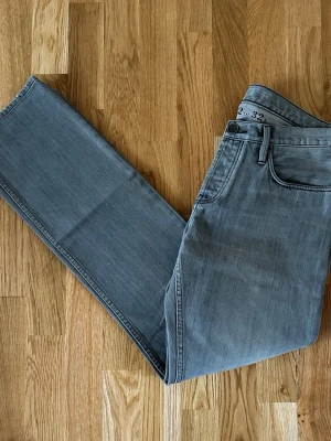 Ljusgrå raka jeans - Snygga ljusgrå jeans med rak passform och klassisk femficksdesign. Jeansen har en enkel look utan slitningar eller dekorationer, perfekta för en clean stil. Materialet är mjukt denim som ger en bekväm känsla hela dagen.