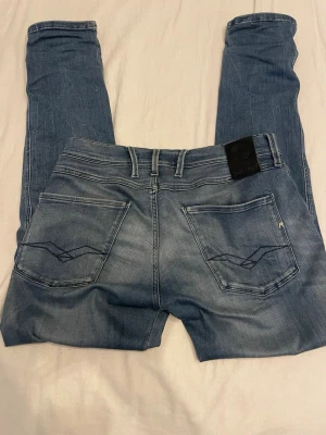 Blå Replay Anbass jeans herr - Säljer ett par blå jeans från Replay, Modellen heter Anbass och det är slimfit. Riktig sköna jeans med hyperflex material,ända defekten är lite slitning men det syns inte. Defekten ser ni på bild 5. Pris kan diskuteras vid snabb affär