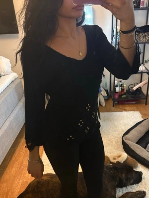 Svart stickad tröja med spetsdetaljer - Detalj på ärmar och mitten 