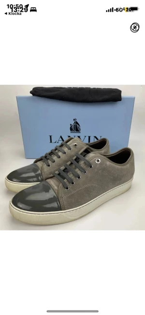 Gråa Lanvin sneakers med lackdetalj - Snygga gråa sneakers från Lanvin med ovandel i mocka och glansig lackad tå. Perfekt för dig som gillar stilrena och exklusiva sneakers med unika detaljer. Nypris 4500 mitt pris 3000