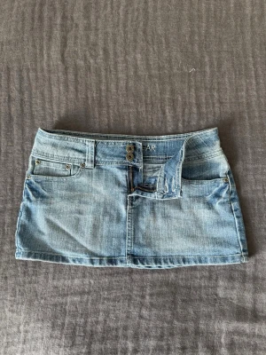 Ljusblå jeanskjol med dragkedja - Säljer en ljusblå lågmidjad jeanskjol från Wear. Kjolen har en kort modell, sitter jätte skönt och är perfekt till sommaren. Snygg och enkel att matcha med olika plagg. Fråga gärna om mått!! 