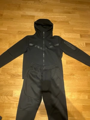 Svart Nike Tech Fleece hoodie - Säljer en helt ny svart nike tech set. Om du vill ha dem separat, Hör av dig. Helt ny! Det är M men sitter bra på S också.
