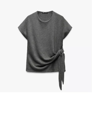 Grå topp med knyt i sidan - Snygg grå topp från Zara med korta ärmar och trendig knytning i sidan. Toppens material känns mjukt och har en lätt stickad look, perfekt för en chill och stilren vibe.