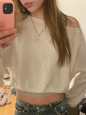 Vit cropped stickad tröja - Säljer en jätte fin  vit cropped stickad tröja med bred ribbad mudd i nederkant och långa ärmar. Tröjan har en avslappnad passform och en lätt off-shoulder design. Perfekt att matcha med höga jeans för en trendig look. tröjan är beige och är i bra skick, lite nopprig men inget man tänker på när man har den på sig. hör av dig om du har några frågor eller funderingar 💕