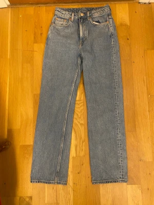 Blå raka jeans från weekday, hög midja - Klassiska blå jeans från weekday, straight leg och hög midja. Storlek: W 24 L 28