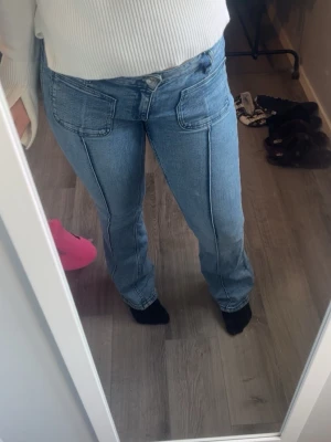 Blå jeans med raka ben och fickor - Snygga ljusblå jeans med raka ben och stora framfickor. Jeansen har hög midja och markerade sömmar längs benen för en cool look. Perfekta för dig som gillar en avslappnad men trendig stil. Storlek 164 men passar mig som har S