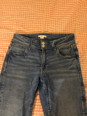 Blå flared low waist jeans - Jag säljer ett par blåa jeans från ginayoung med fina fickor och tvåknappar där fram! Jag har knappt använt dessa jeans och dom är helt i nyskick!!🩷🩷🩷dom är i strlk 170