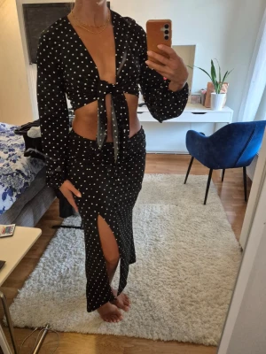 Set, kjol och topp - Säljer ett set från Gina Tricot med matchande kjol och topp. Använda vid ett tillfälle, skicket är som nytt. Kjolen har slits på ena sidan och toppen knyts mellan bysten. 98% polyester, 2% elastan