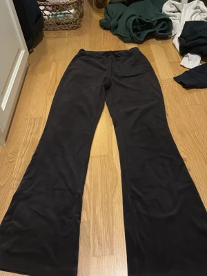 Svarta utsvängda leggings - Säljer ett par svarta leggings med utsvängda ben. De har en hög midja och är gjorda i ett mjukt, stretchigt material som sitter skönt på kroppen. Perfekta för dig som gillar en avslappnad men trendig stil.