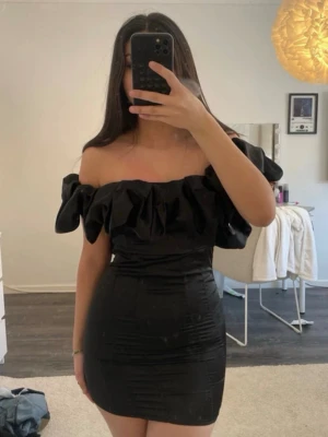 Svart off-shoulder miniklänning - Pris kan diskuteras!! Säljer en svart, tight och kort off-shoulder klänning med volang upptill. Säljer då den är för liten för mig, helt oanvänd endast testad💗