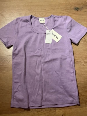 Ljuslila t-shirt från Signe - Snygg ljuslila t-shirt från Signe i mjuk ekologisk bomull. Klassisk rund halsringning och korta ärmar. Perfekt basplagg för en avslappnad och trendig stil.