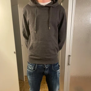 Grå stickad hoodie - Säljer en stilren stickad grå hoodie. Perfekt för en avslappnad look.