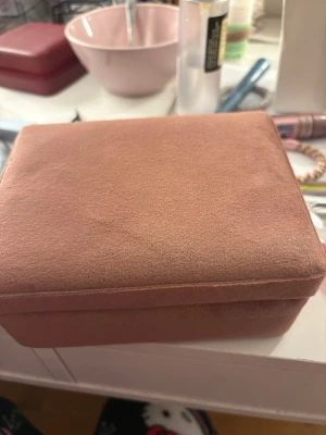 Brun smyckesask i sammet - En stilren smyckesask i mjuk brun sammet med svart insida. Perfekt för att förvara ringar, halsband eller andra små accessoarer. Rektangulär form och praktisk storlek som passar på sminkbordet eller i väskan.