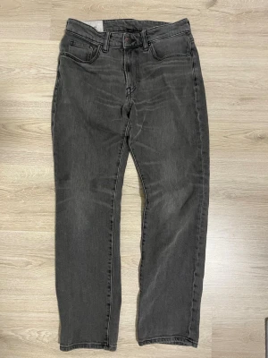 Gråa regular fit jeans från H&M - Säljer ett par gråa jeans från H&M med regular fit. Jeansen har klassisk femficksdesign, raka ben och knappstängning. Perfekta för dig som gillar en avslappnad och enkel stil. Materialet är denim och färgen är snyggt tvättad grå.