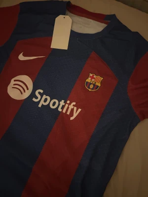 FC Barcelona matchtröja Nike blå/röd - Säljer en officiell FC Barcelona matchtröja som är perfekt för dig som stöttar Barcelona och vill ha en perfekt tröja för sommaren den är aldrig andvänd innan och inget nummer eller namn på ryggen 