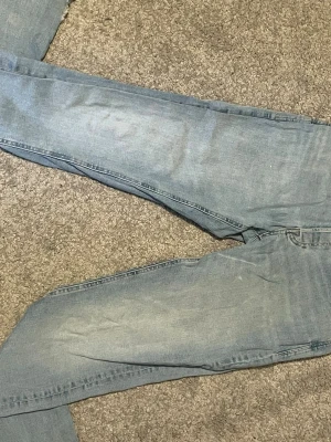 Ljusblå jeans från Jack & Jones - Säljer ett par ljusblå jeans från Jack & Jones, modell Comfort/Mike. Jeansen har klassisk femficksdesign och raka ben. Materialet är denim med snygga slitningar och ljus tvätt. Perfekta för dig som gillar en avslappnad stil.