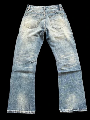 Blå slitna raka jeans - Säljer ett par blå jeans med rak passform och slitna detaljer framtill. Jeansen har klassisk femficksdesign och ljus tvätt med tydliga slitningar för en cool vintagekänsla. Perfekta för dig som gillar en avslappnad och trendig stil. DOM ÄR HELT OANVÄNDA  Nypris:549kr köpt ifrån pieces of life studios W30 L 32