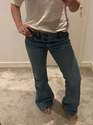 Blå bootcut jeans från Levi's - Säljer ett par klassiska blå bootcut jeans från Levi's med normalhög midja, storleken är W26 L32 nästintill aldrig använda då dem är för långa för mig.