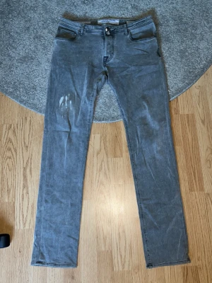 Grå slim fit jeans från Jacob cohën - Snygga gråa jeans från jacob cohën, de har modellen 688 och har en rak passform. De har skicket 7/10 och har en cool design på framsidan. 