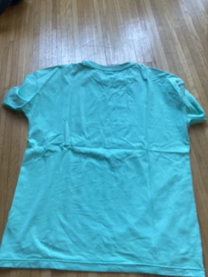 Turkos t-shirt med blå text - Snygg turkos t-shirt med trycket 'CONNECTED' i flera rader på bröstet i mörkblått. Klassisk rund hals och korta ärmar. Perfekt för dig som gillar enkel men cool stil.