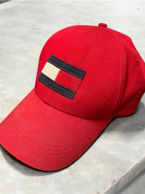 Tommy Hilfiger Keps - Tja! Den är i mycket bra skick utan några defekter. Storlek One Size och den är justerbar där bak. Nypris runt 500kr. Hör av dig vid minsta fundering!